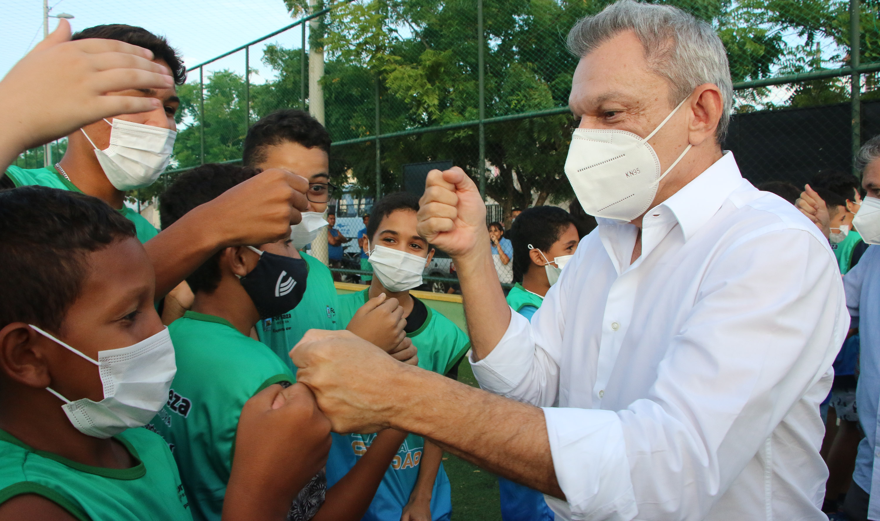 prefeito cumprimenta crianças e adolescentes na entrada da areninha